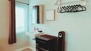 A bathroom with a sink, mirror, and black cabinet. - Walk to food & drinks, near lakes (Mossyrock)