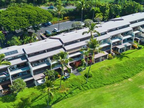 A multi-story hotel with a flat roof, balconies, and a parking area. - Country Club Villas - Golf, Air Conditioning & Oceanview (Kailua Kona)