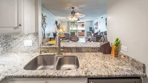 A kitchen with granite countertops, a double sink, and an LG dishwasher.