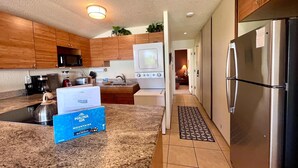 Une cuisine moderne avec des meubles en bois, un réfrigérateur en acier inoxydable et un four à micro-ondes.