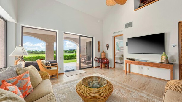 Amplia sala de estar con televisor grande, asientos cómodos y vistas al exterior.