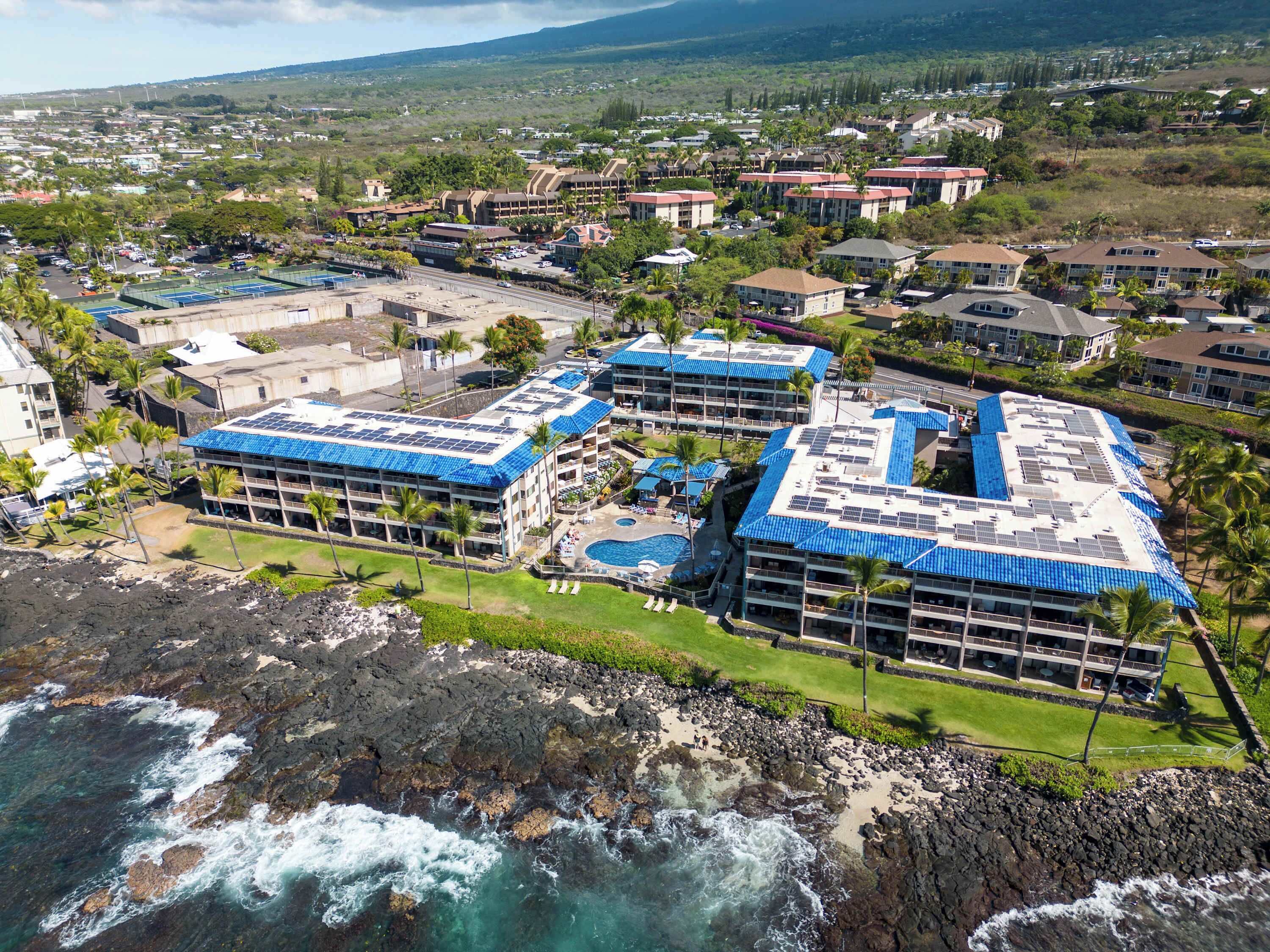 Un hôtel situé sur la côte, composé de plusieurs bâtiments, doté d’une piscine et bordé d’une plage rocheuse.