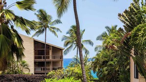 A hotel with a modern design, featuring a large building with multiple balconies and a view of the ocean.
