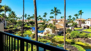 Un resort con varias villas, piscina y jardín ajardinado con palmeras.
