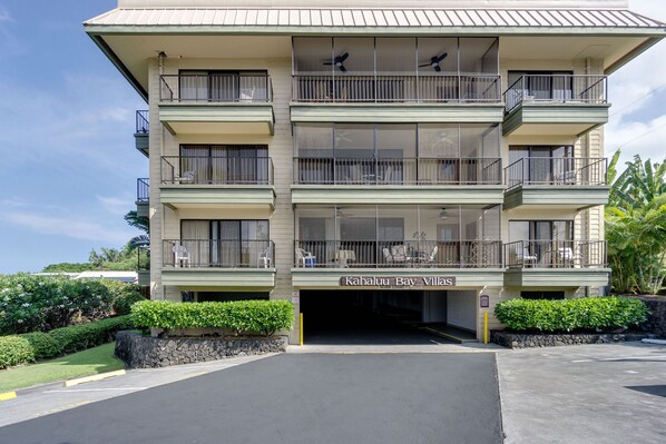 Un hotel de varios pisos con balcones y un cartel que dice "Kahului Bay Villas".