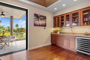 Una cocina con armarios de madera, una encimera con un lavabo y vistas al exterior.