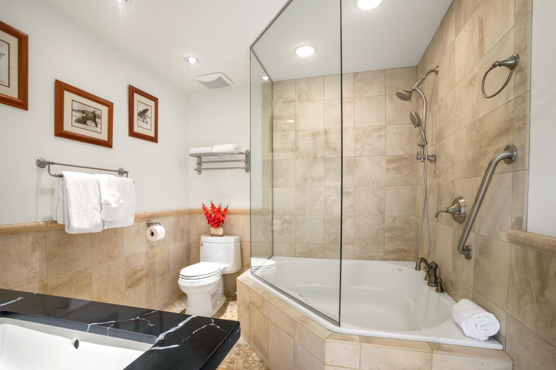 Une salle de bain moderne dotée d’une douche à parois de verre, d’une baignoire sur pied et d’un meuble-lavabo en marbre.