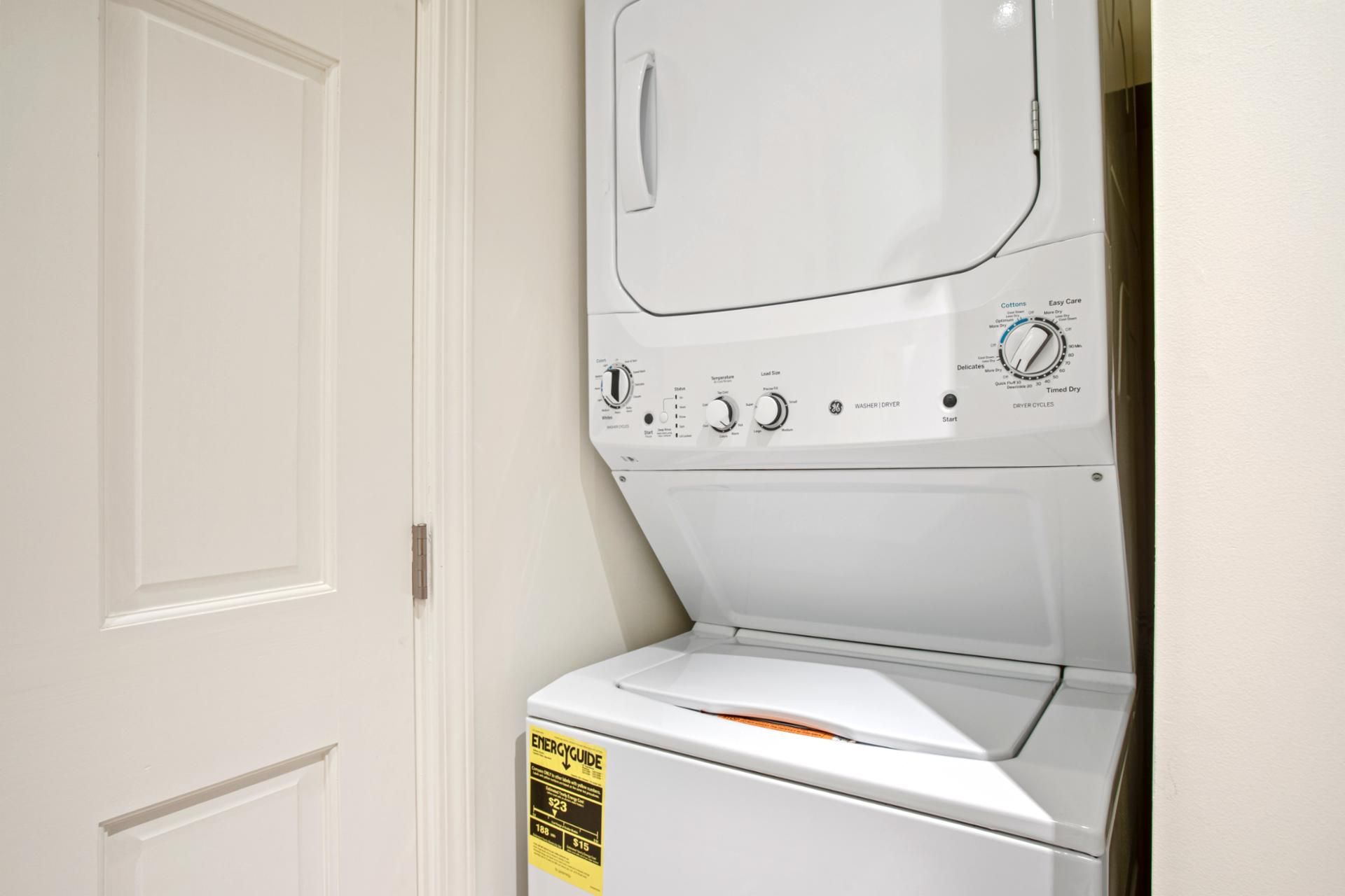 Un appareil combiné lave-linge et sèche-linge à chargement frontal, doté de boutons de commande et d’une étiquette indiquant son niveau d’efficacité énergétique.