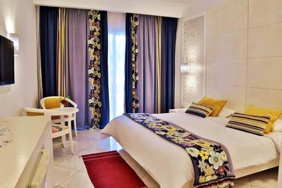A hotel room with a bed, a desk, and a chair.
