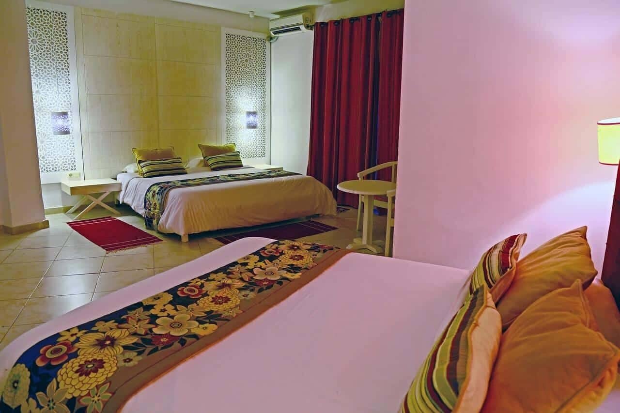 A hotel room with a bed, a small table, and a chair.