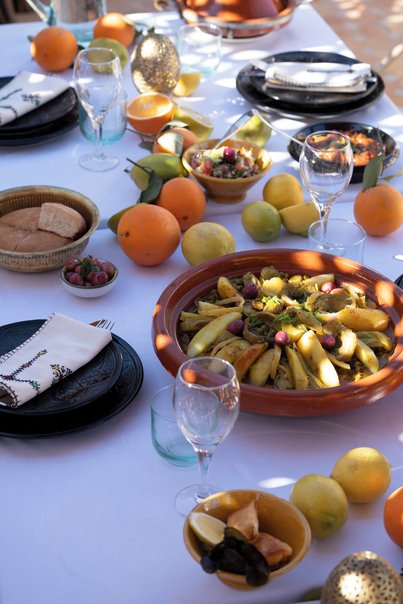 Una mesa dispuesta con frutas variadas, un cuenco de cuscús y copas de vino.