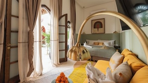 Un dormitorio con cama, mesita de noche, lámpara y ventana con cortinas.