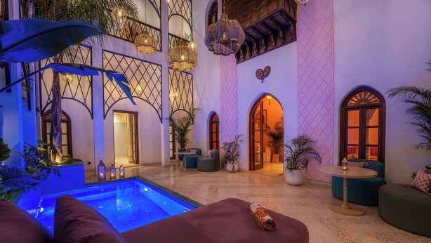Un área de piscina interior lujosa con zona de estar, una escalera y vistas a la piscina.
