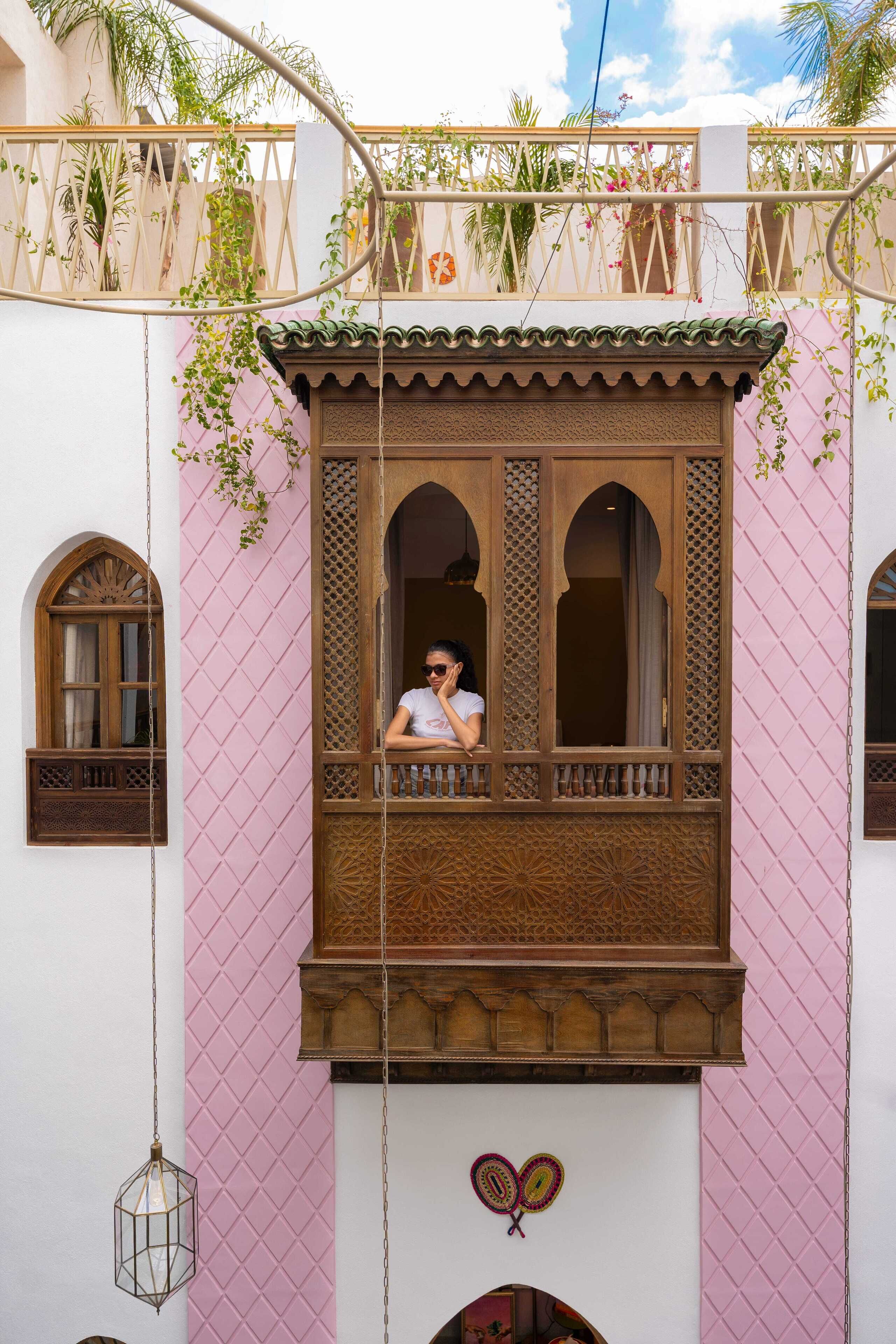 Un balcone con una persona, un cuore decorativo e un lampadario.