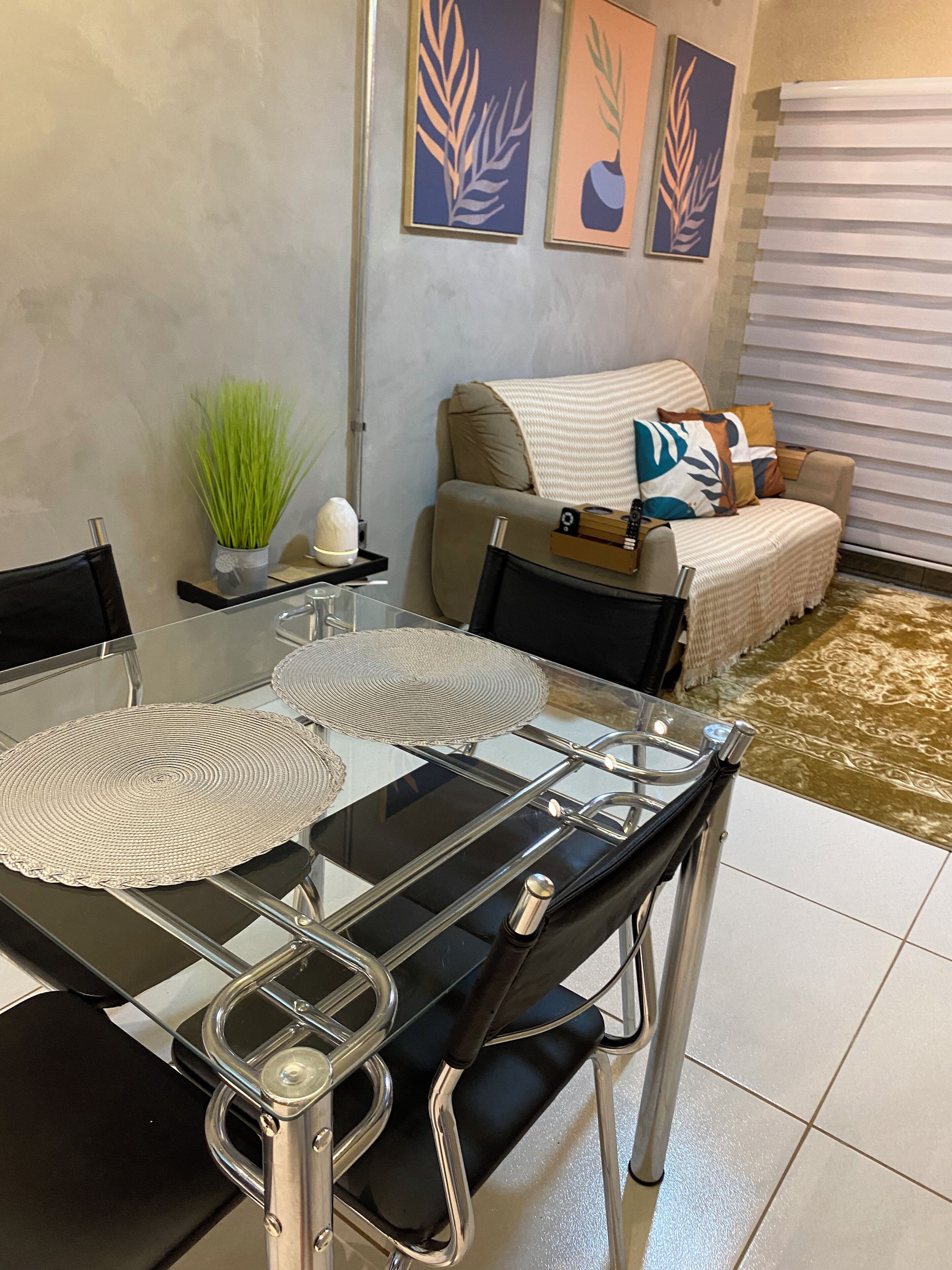 A modern dining area with a glass table, black chairs, and a decorative centerpiece.