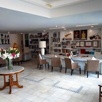 Una sala de estar moderna con una mesa de centro, sillas, una estantería y un escritorio con una computadora.