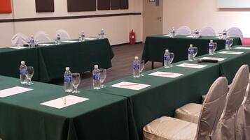 A conference room with tables set for a meeting, equipped with water bottles and glasses.