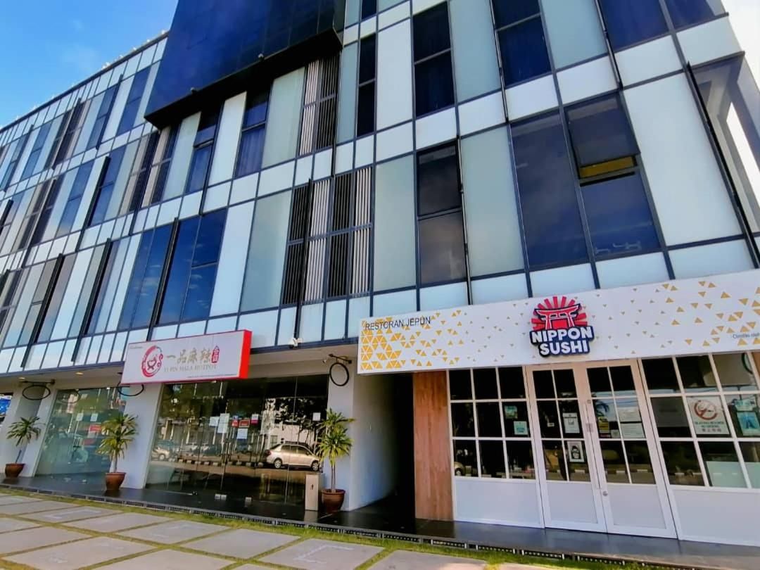 A modern building with a glass facade, a restaurant named 'NIPPON SUSHI' on the ground floor, and a sign for 'RESTORAN JAPON' above the entrance.