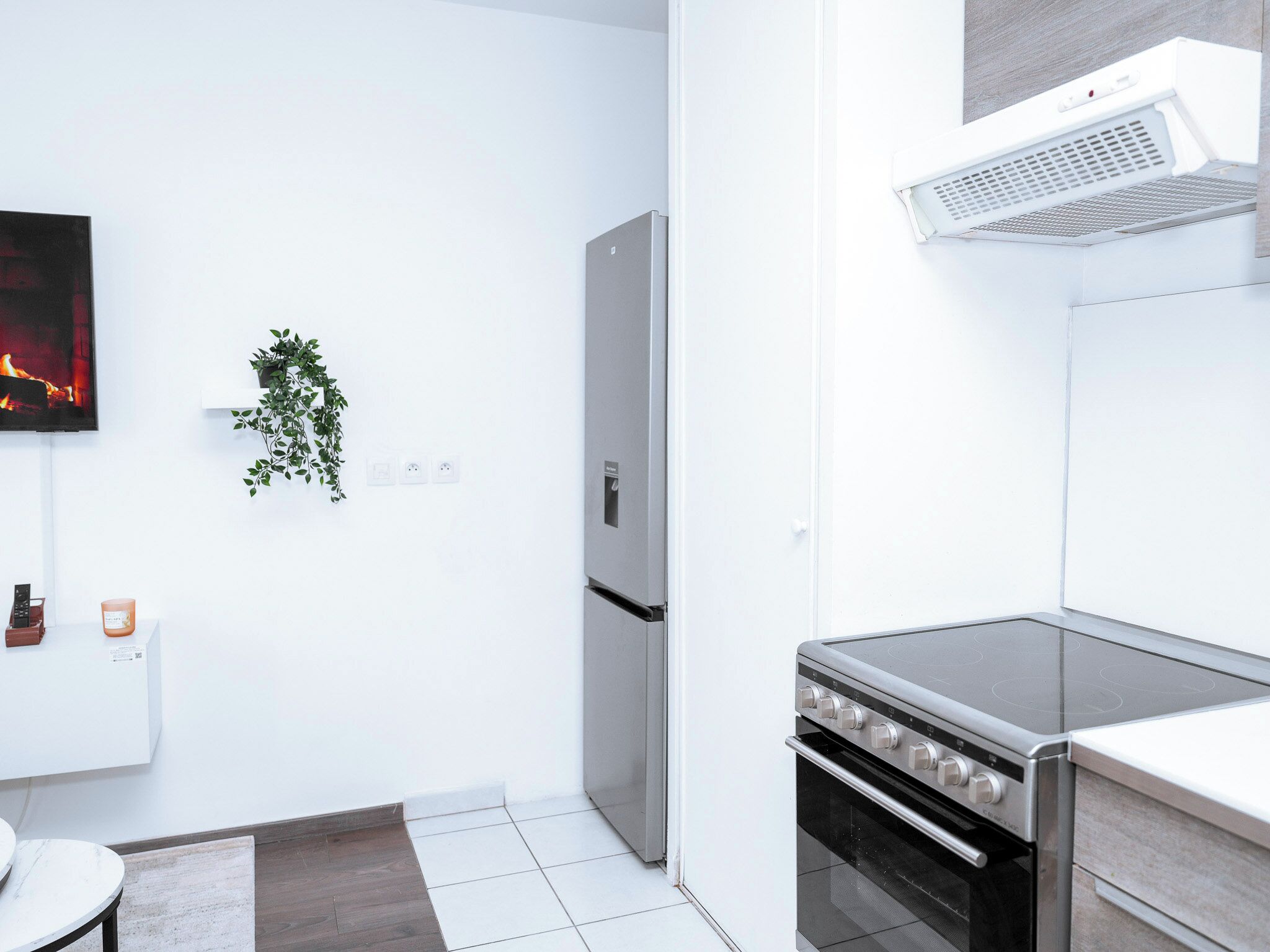 Una cocina moderna con horno empotrado, estufa de acero inoxidable y extractor de aire mural.