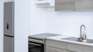A modern kitchen with a built-in oven, a stainless steel sink, and grey cabinetry.