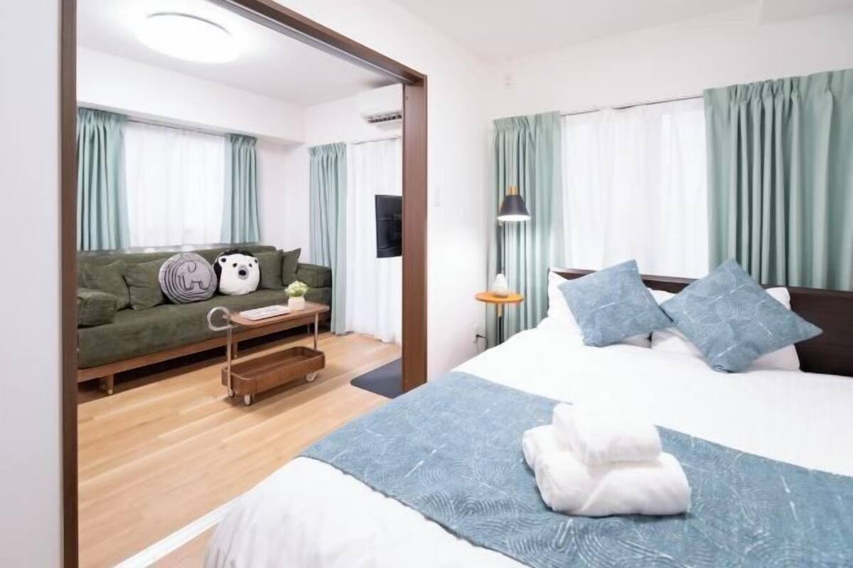 Een hotelkamer met een bed, een slaapbank, een klein tafeltje en een televisie.