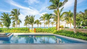 A pool area with lounge chairs and palm trees. - Beachfront Luxury Villa: Your Private Paradise (Da Nang)
