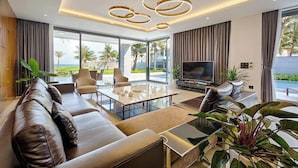 Una sala de estar moderna con un sofá de cuero, una mesa de centro de vidrio y un televisor de pantalla plana.
