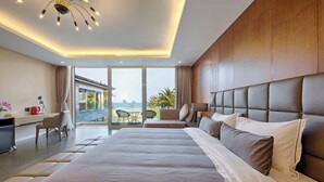Una habitación de hotel moderna con una cama grande, un escritorio y un balcón con vistas.