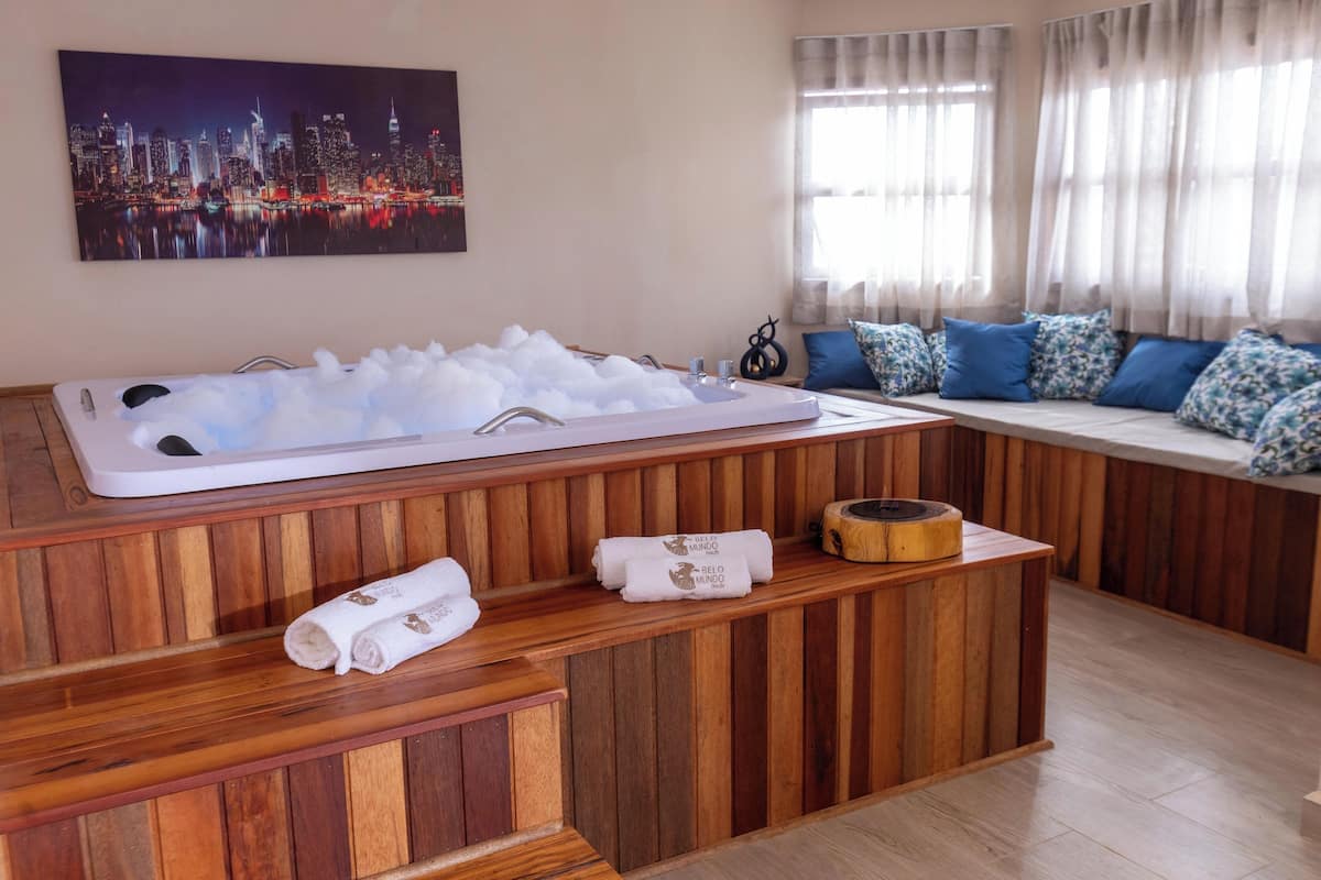 A spa area with a hot tub, wooden seating, and towels.