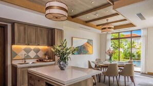 A modern kitchen with wooden cabinets, a large island, and pendant lighting.