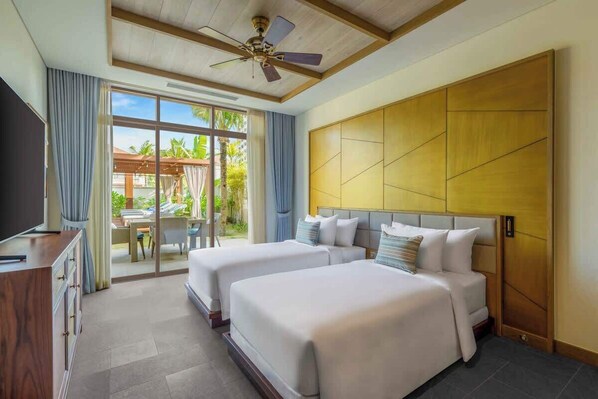 A hotel room with two beds, a desk, and a large window with a view of palm trees.