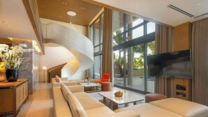 A modern living room with a spiral staircase, large windows, and a flat-screen TV. - Elegant Retreat for Discerning Travelers (Da Nang)