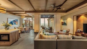 A modern hotel lobby with a wooden ceiling, a central seating area with a sofa and chairs, a dining area with a bar, and artwork on the walls. - Luxe 5BR Villa: Beachfront Breakfast Pool (Da Nang)