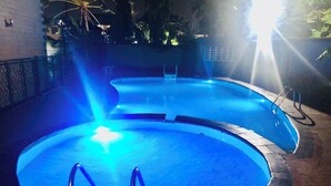 Une piscine dotée d’un système d’éclairage bleu, entourée d’une terrasse en briques.