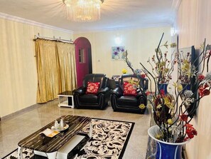 Relax in this stylish living room with a comfortable sofa, coffee table, and beautiful vase with fresh flowers.