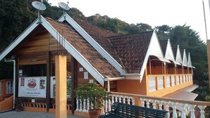 A building with a sloped roof, a balcony with white balustrades, and a signboard. - Pousada Pinhalense (Santo Antonio do Pinhal)
