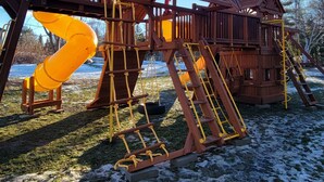 A wooden playground structure with slides and climbing elements. - Ugly Duckling Lodge - Swan Lake Retreat (Dalton)