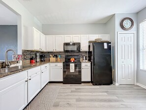 Een microgolfoven, een oven, een kookplaat, een vaatwasser