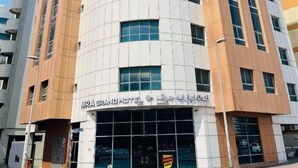 Un hotel moderno con fachada curva, varios pisos y una entrada destacada.