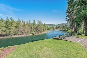 A river with a grassy area and picnic tables. - All Seasons River Inn (Leavenworth)