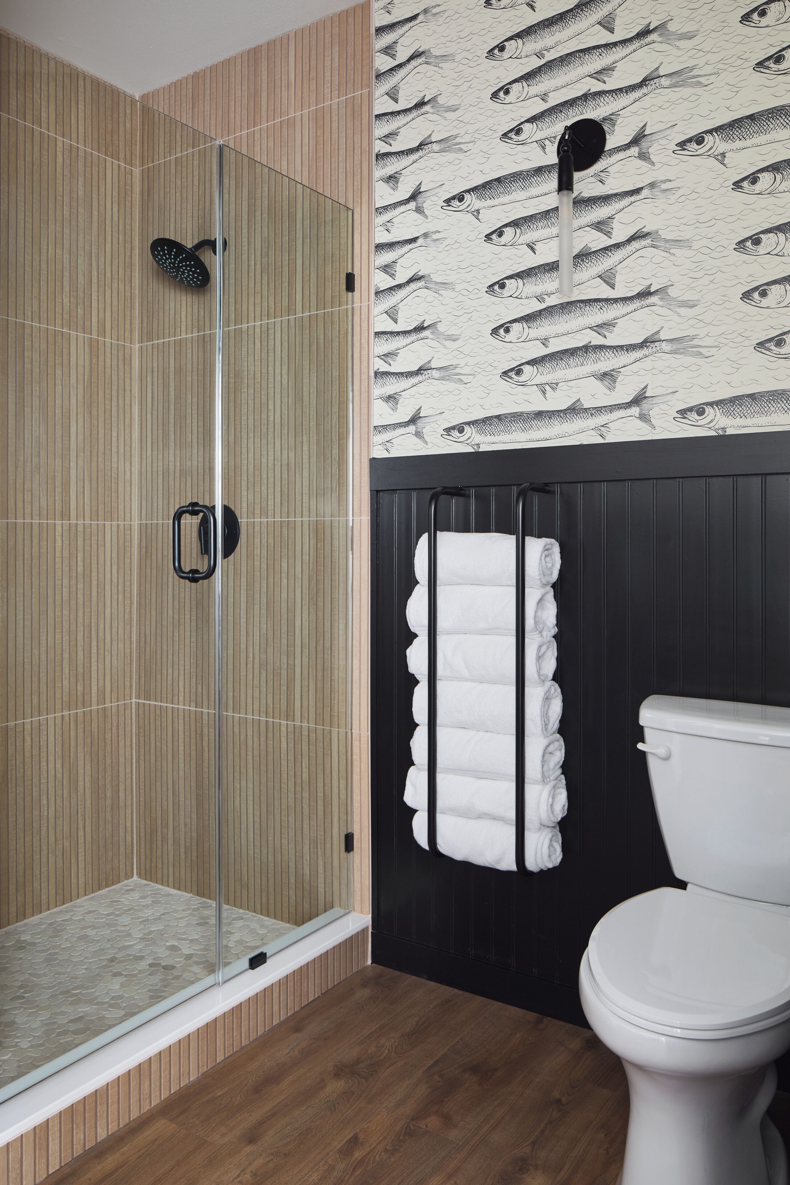 Ein Badezimmer mit Duschkabine, Toilette und Handtuchhalter.
