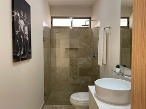 Een douche, handdoeken, zeep, toiletpapier