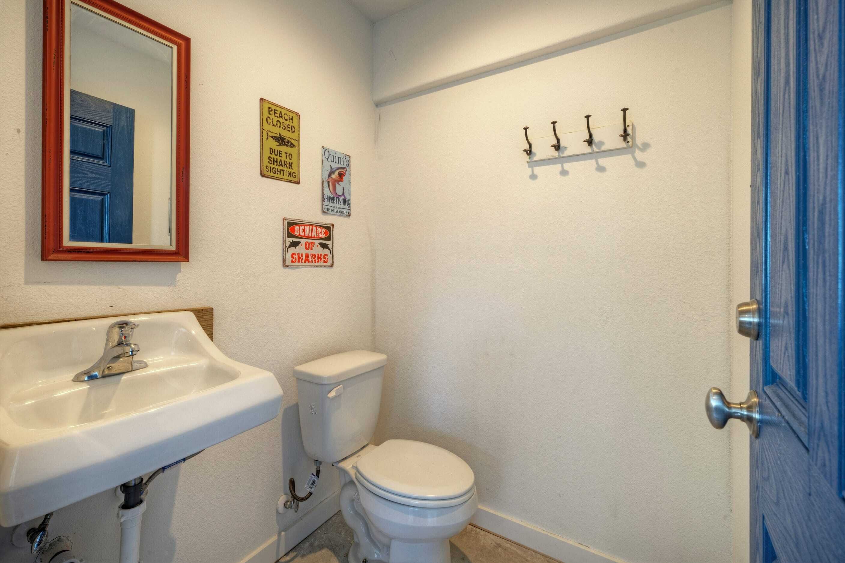 A bathroom with a sink, toilet, and a blue door.