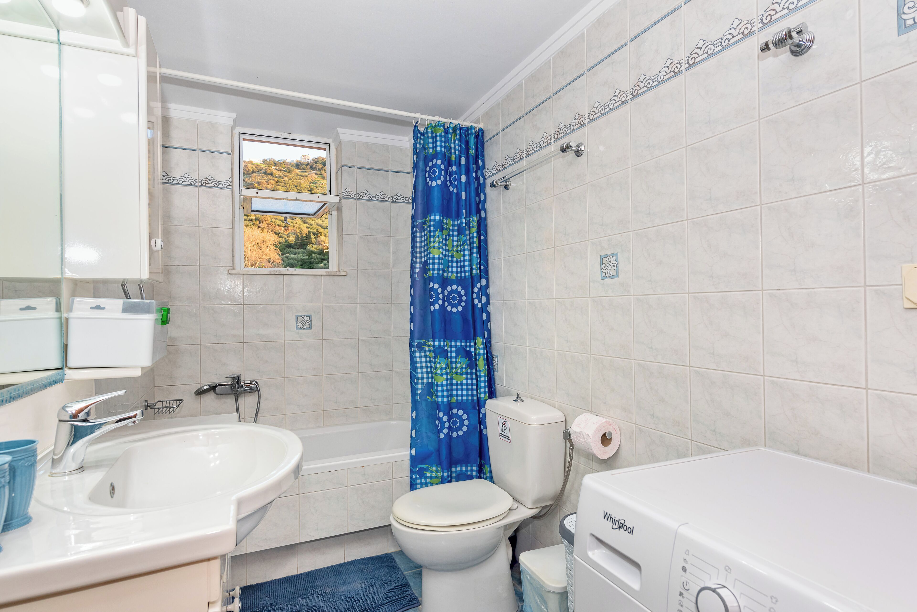 A bathroom with a toilet, sink, and bathtub.