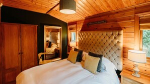 Ein Schlafzimmer mit einem großen Bett, einem Holz-Kopfteil und einem Nachttisch mit einer Lampe.