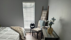 A bedroom with a bed, a chair, a small table with a vase, and a window with blinds. - Masters 2026 Rental! 3 Bed 2 Bath! (Martinez)