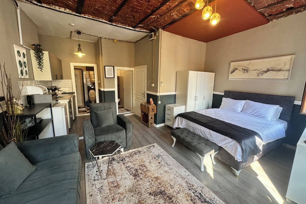 Ein Schlafzimmer mit einem Bett, einem Sessel, einem Schreibtisch und einem Kleiderschrank.