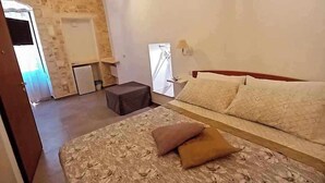 Une chambre à coucher avec un lit, une petite table et une fenêtre.