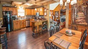Une cuisine spacieuse dotée de meubles en bois, d’un îlot central et d’un coin repas avec une table et des chaises.