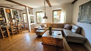 A cozy living room with a wooden floor, a sofa, a coffee table, and a bookshelf. - Kleine Perle am Schwielowsee (Schwielowsee)